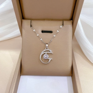 Elegant silver dolphin pendant necklace with shimmering crystals on a white silk background