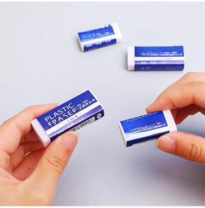 Close-up of white 2B plastic erasers with blue paper sleeves held in hands