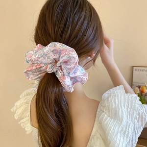 Chouchou floral avec perles porté en queue de cheval aux motifs de fleurs roses et bleues
