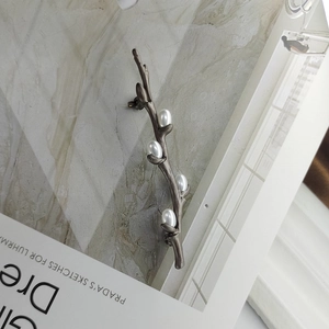 Detail shot of vintage plum branch brooch with white pearls on a stylish background