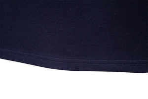Close-up of navy blue pique knit fabric showing detailed hem stitching on long sleeve polo shirt