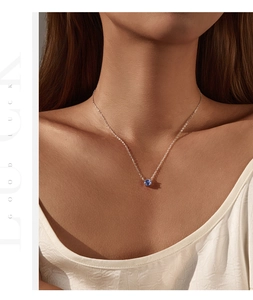 Détail du collier S925 en argent avec pendentif tanzanite porté sur une chaîne dorée