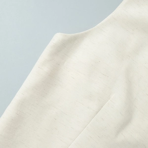 Close-up of high-quality cotton linen fabric texture and stitching details on a white vest
