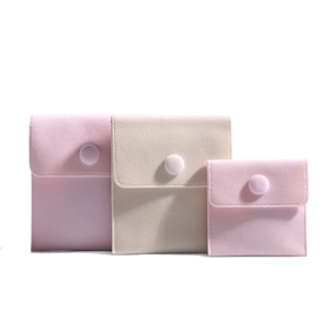 Pink velvet jewelry pouches with snap button closure in three different sizes on white background