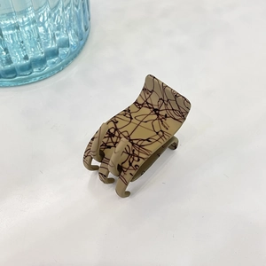 Détail de la pince à cheveux kaki mat avec texture marbrée d'encre brun foncé