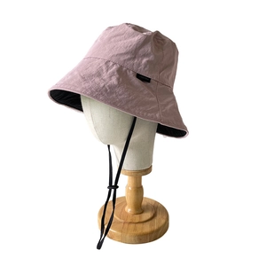 Pinkish purple reversible nylon sun bucket hat with adjustable black drawstring and wide brim