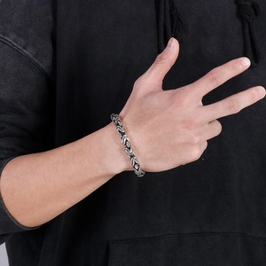 Close-up of a silver men's titanium steel king chain bracelet worn on a wrist