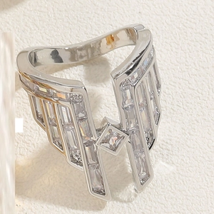 Macro shot of V-shaped silver wing ring with sparkling rectangular zircon stones