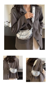 Detail view of silver dumpling bag with metallic chain and pleated PU leather texture