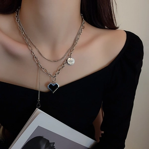 Vue détaillée du collier double argenté avec pendentif rond et cœur pixelisé noir