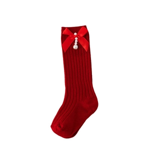 Red knit children socks with satin bows and pearl charms for Christmas and New Year