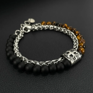 Detail of silver chain bracelet with matte black beads, tiger eye stones and cross charm