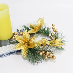 Christmas wreath with gold poinsettia and pine needles next to a yellow candle
