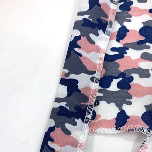 Close-up of camouflage outdoor bandana with durable white overlock stitching and soft fabric