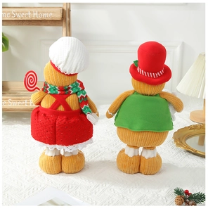 Detailed back view of two knit gingerbread dolls with scarf on a festive wooden shelf