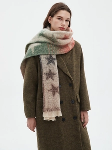 Detail of soft jacquard loop yarn scarf featuring a colorful star pattern and fringe edges