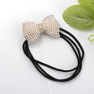 Vue détaillée du nœud orné de strass et perles sur un élastique à cheveux noir