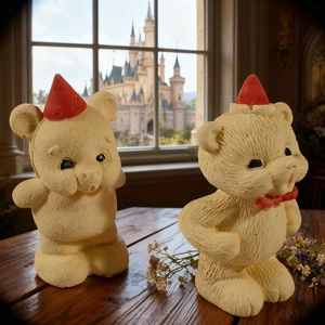 Detail von matten cremefarbenen Bärenfiguren mit roten Weihnachtsmützen auf dunklem Holz