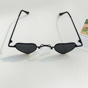 Detail view of heart-shaped black children's sunglasses with metal frames and soft nose pads