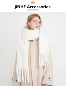 Close-up of fluffy white cashmere-like scarf showing soft texture and long fringe details