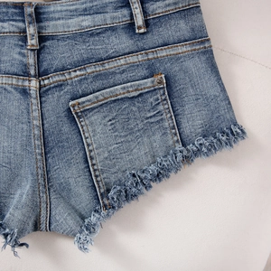 Detailansicht der blauen Denim-Shorts mit ausgefransten Kanten und Vintage-Waschung