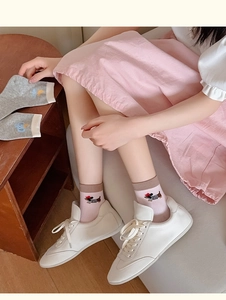 Detail of pink and gray cotton socks with cute cartoon animal embroidery on the ankle