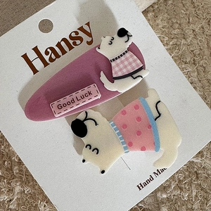 Close-up of cute purple cartoon dog hair clips set on a handmade display card