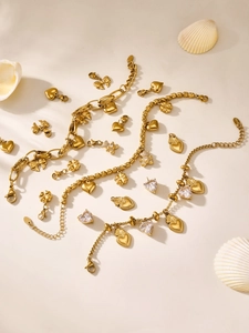 Detailaufnahme von goldenem Edelstahlschmuck Set mit Kleeblatt- und Herzanhängern