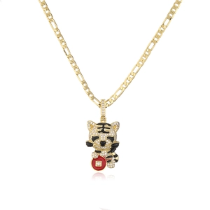 Macro shot of 18K gold plated tiger pendant with sparkling cubic zirconia on Figaro chain