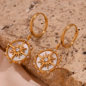 Détail de boucles d'oreilles étoile polaire plaquées or 18K avec nacre et zircons
