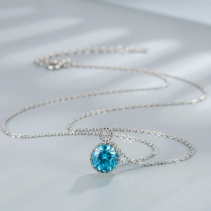 Elegant S925 sterling silver Heart of Ocean necklace with a round blue gemstone pendant