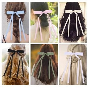 Detailed view of long satin ribbon bow hair clips in multiple colors for various hairstyles