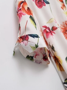 Détail du poignet bouffant avec nœud et imprimé floral éclatant sur tissu en popeline