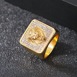 Close-up of golden lion head signet ring with sparkling rhinestones on black background