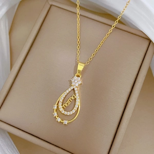 Détail du pendentif goutte MAMA doré avec cristaux sur le rembourrage du coffret à bijoux