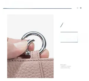 Detailed view of silver metal spring hook on pink pebble grain leather coin purse