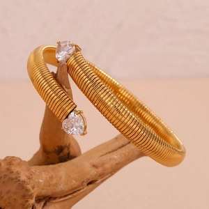 Detail of 18K gold-plated striped bangle with two heart-shaped cubic zirconia stones