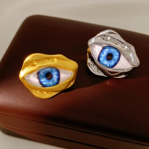 Detail of gold and silver irregular lava rings featuring realistic blue eye design