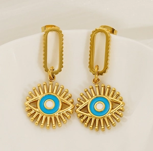 Detailed macro shot of gold stainless steel evil eye earrings with blue enamel finish