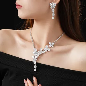Elegant flower necklace and drop earrings set with sparkling zircons on female model
