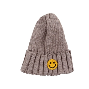 Taupe thick knit beanie for children featuring a yellow smiley face embroidered patch
