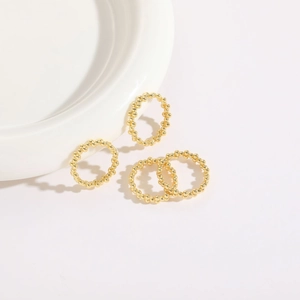 Detail shot of four 14K gold-plated beaded rings arranged on a white ceramic plate