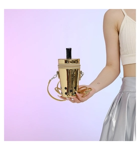 Detail of creative gold milk tea cup shaped crossbody bag with chain strap and straw design