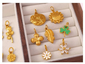 Detailed view of assorted gold flower pendants with enamel and gems in a jewelry box