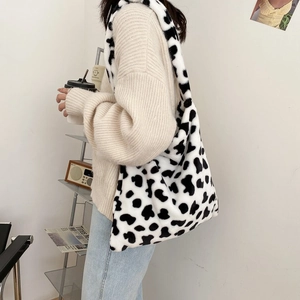 Lifestyle shot of large faux fur cow print tote bag showing size and casual wear style