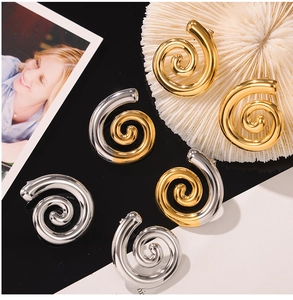 Détail de boucles d'oreilles spirales géométriques or et argent avec finition polie brillante