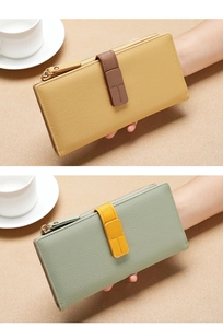 Detailed view of long leather wallets in yellow and light green with pebbled texture