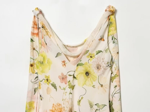 Détail d'une élégante robe fleurie beige sans manches avec motifs de papillons délicats