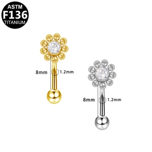 Detailed view of G23 titanium eyebrow piercings with flower-shaped clear gemstones