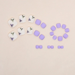 Matte purple toe press-on nails set featuring delicate pansy floral patterns and white accents